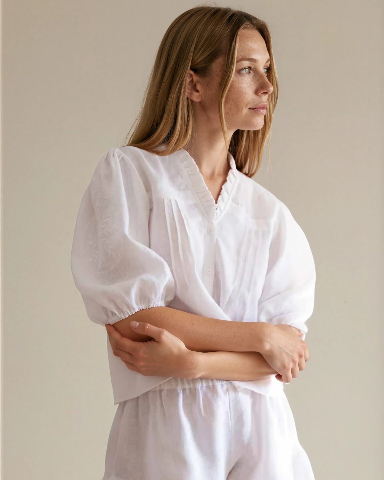 Woman wearing a white linen outfit with ruffled shorts 