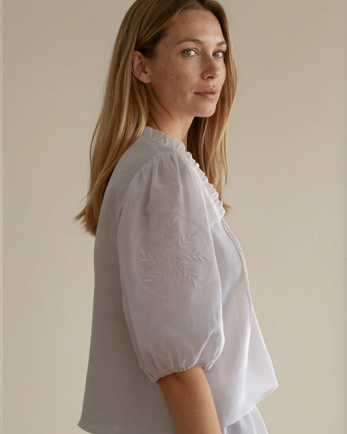 Woman wearing a white blouse with embroidered sleeves