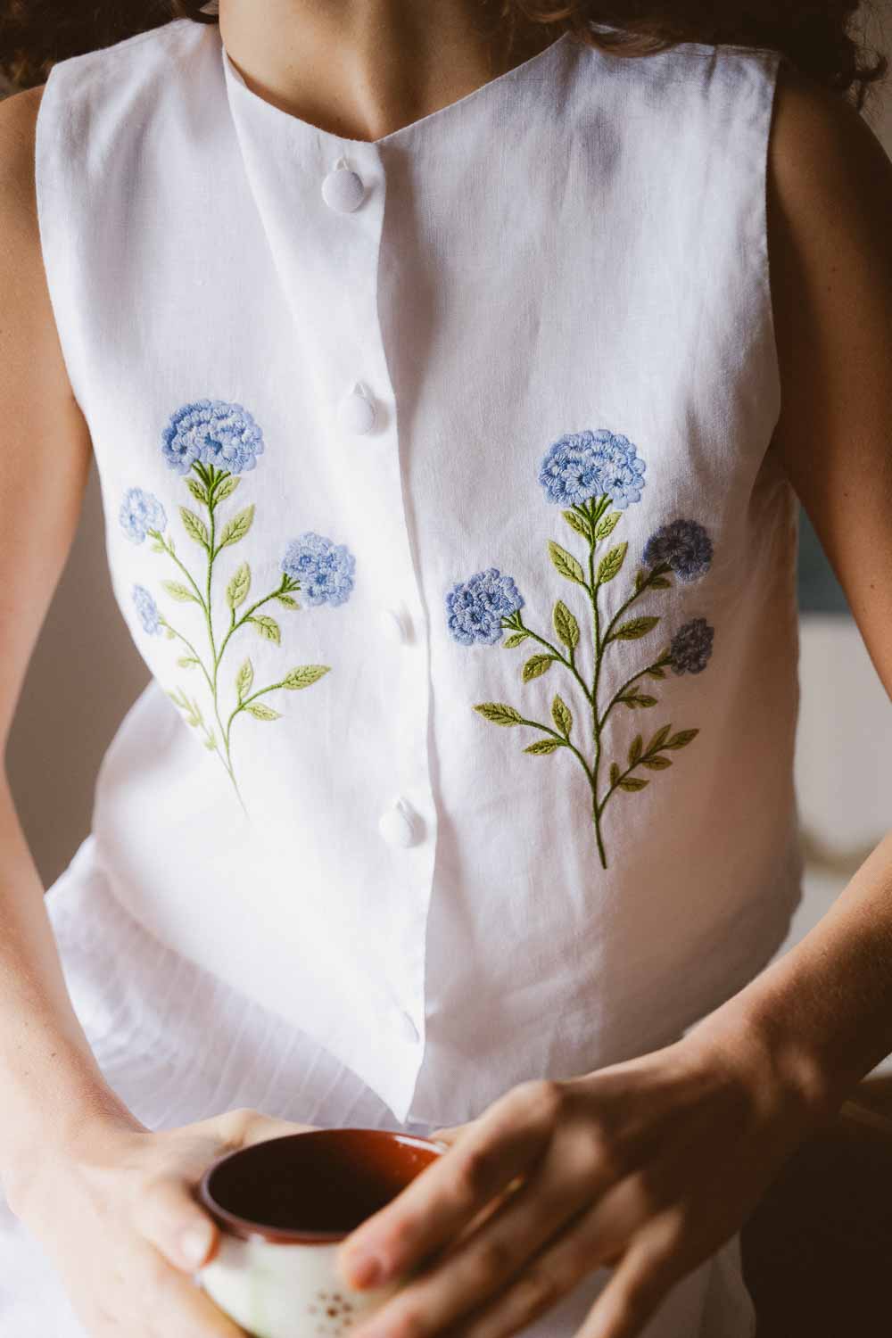 White sleeveless top with floral embroidery
