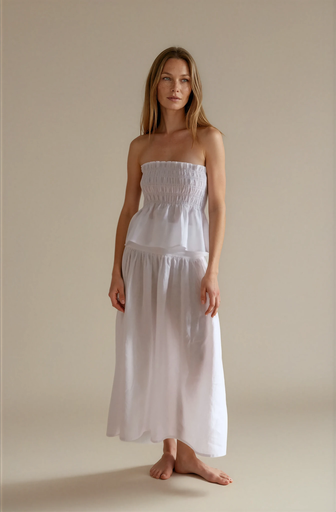 Woman wearing a white strapless top and a linen midi skirt 