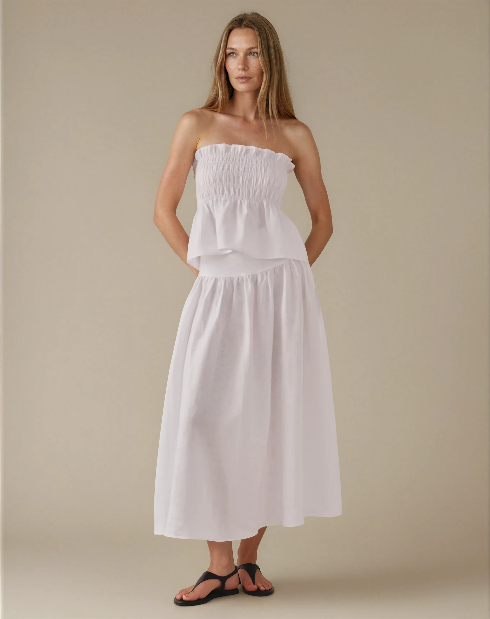 Woman wearing a strapless white top and midi skirt 