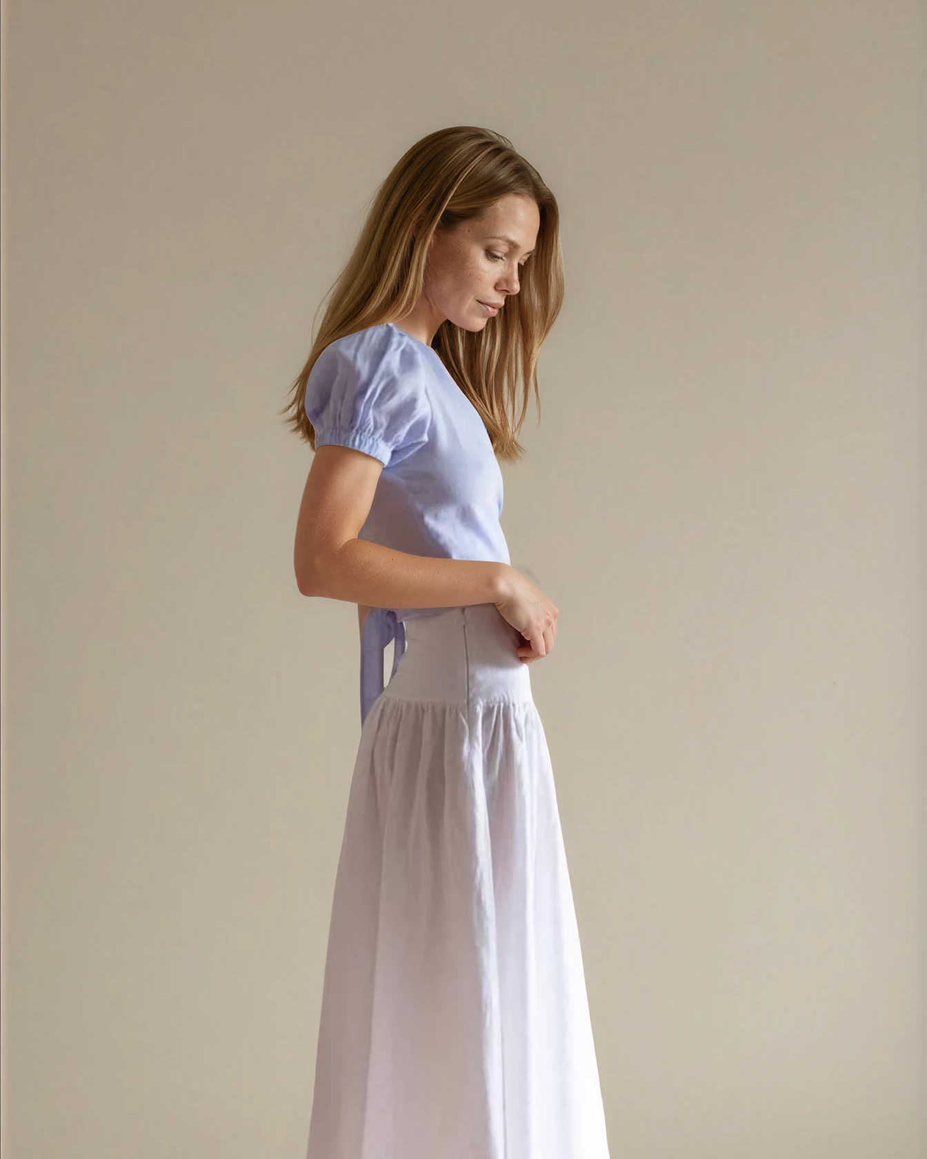 Woman wearing a baby blue top and white skirt 